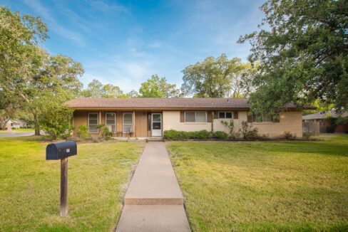 Front view of a single-story residential house with a concrete walkway and mailbox.
