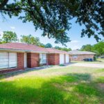 Single-story brick house with a large front yard and trees in Aggieland Leasing's service area.