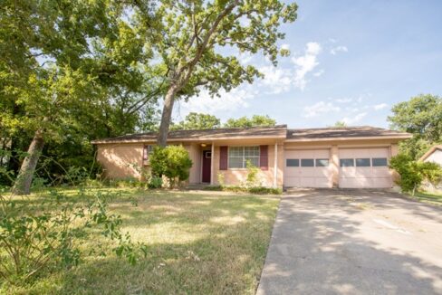Single-story house with a two-car garage and front yard in Aggieland, Texas.