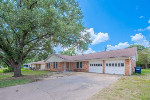 Single-story brick house with attached garage and large front yard in Aggieland.