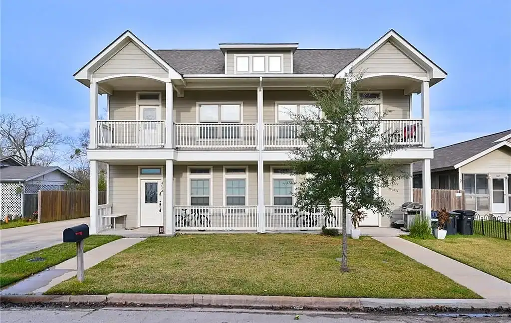 Front view of a two-story residential building with balconies in Aggieland, Texas.