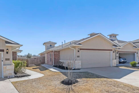 View of a modern residential house with a two-car garage and a small front yard.