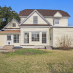 Back view of a two-story house with a small porch and large windows in College Station.
